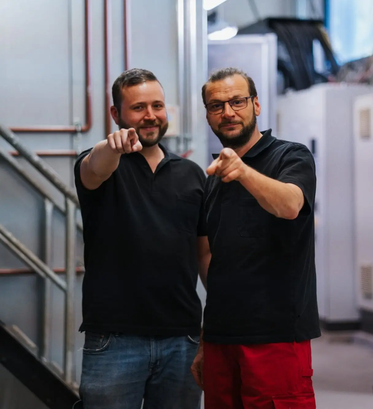 Zwei Mitarbeitende die in deine Richtung zeigen und genau dich meinen