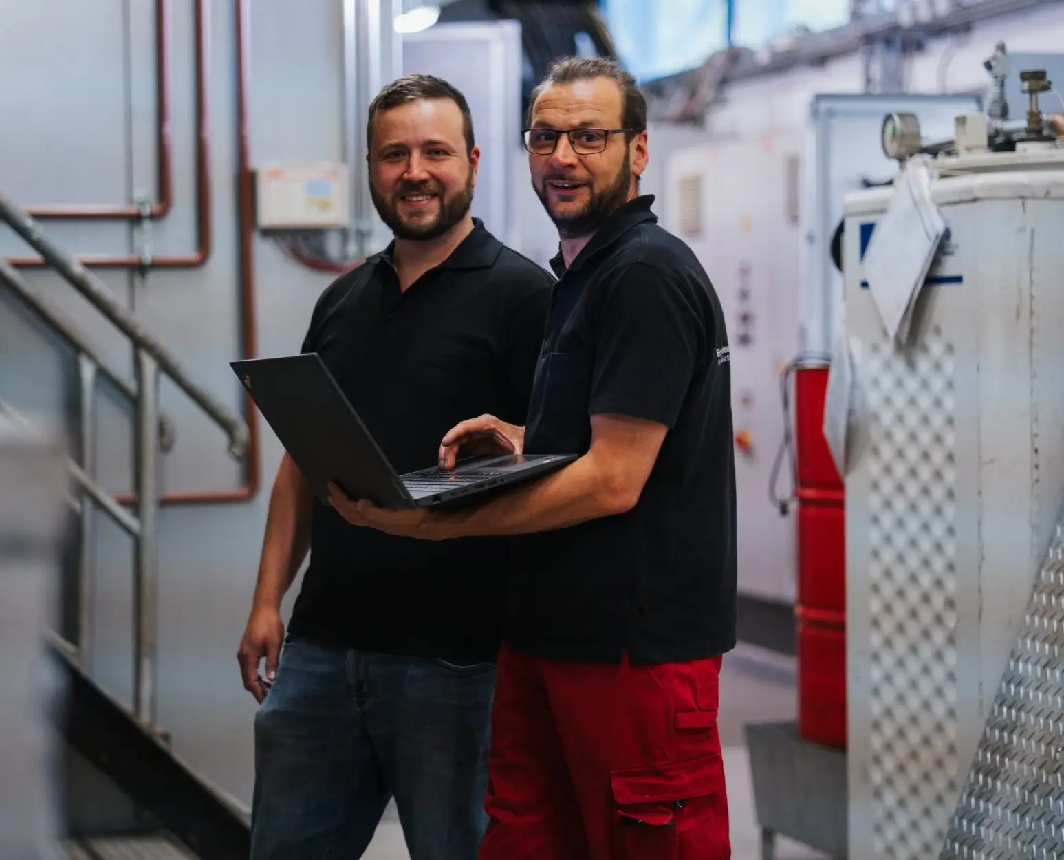 Zwei männliche Mitarbeitende in einem Heizungsraum